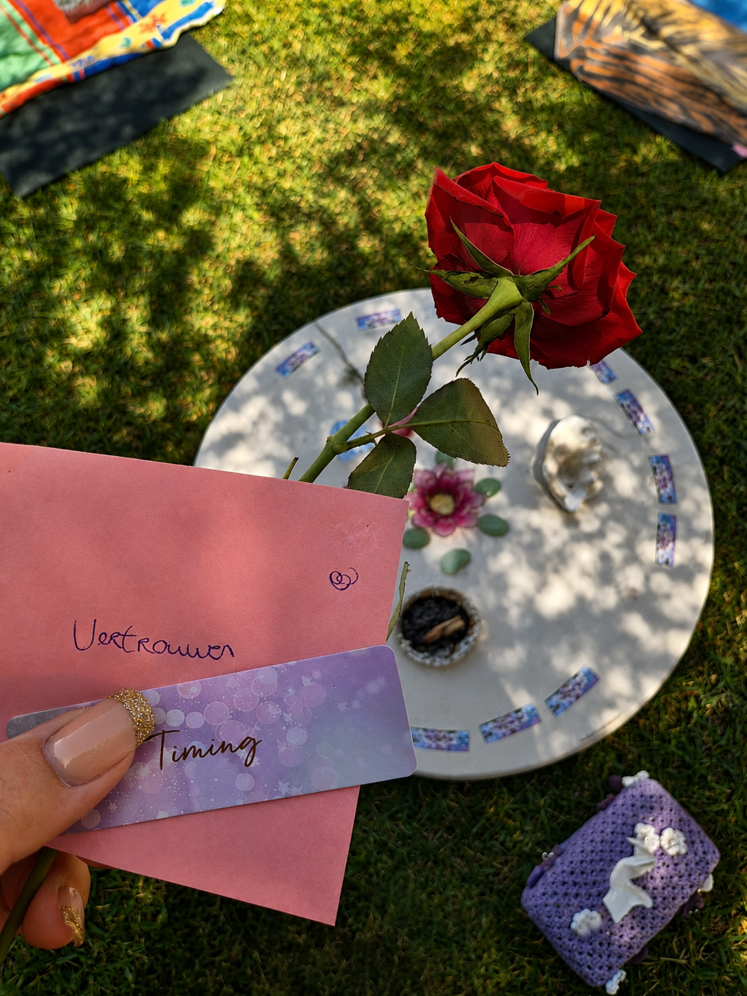 A rose and cards laid out on the grass during a quiet ritual